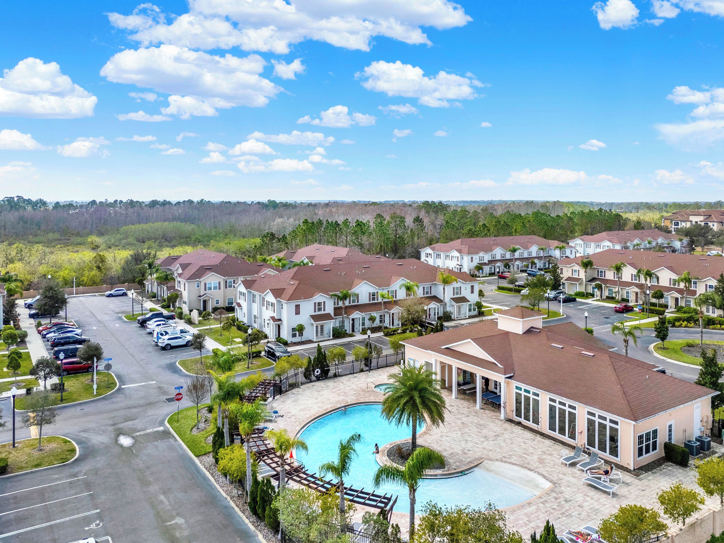 A residential area with multiple two-story houses, a swimming pool, and a parking lot.