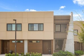 A modern two-story building with a flat facade, large windows, and a central vertical feature. - Pininfarina Masterpiece 4 BD/4.5 BA - 5534 PW (Kissimmee)