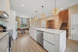 A modern kitchen with a central island, stainless steel appliances, and pendant lighting. - Modern Oasis 4 BD/4.5 BA Magic Village by Pininfarina - 5501 TR (Kissimmee)