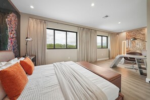 A modern hotel room with a large bed, a desk, and a view of the outdoors. - Modern Oasis 4 BD/4.5 BA Magic Village by Pininfarina - 5501 TR (Kissimmee)