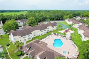 A residential area with apartment buildings, a swimming pool, and a tennis court. - 3 BD/ 2 BA/ The Villas at Laguna Bay (5017-95 LB) (Kissimmee)