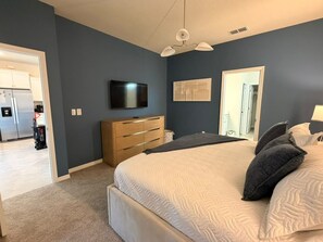 A bedroom with a bed, a television, a dresser, and a mirror. - 5 BD/ 5.5 BA/ Windsor Cay - 16007 CC (Clermont)