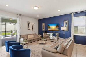 A modern living room with a sofa set, a coffee table, and a TV mounted on the wall. - 8 BD/ 6 BA/ Windsor Island - 2290 LC (Davenport)