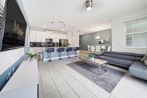 A modern kitchen with white cabinets, a central island, and bar stools. - 4 BD/ 3 BA/ Storey Lake - 4816 ML (Kissimmee)
