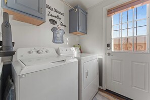 Ein Waschraum mit Waschmaschine, Trockner und einem Schild mit der Aufschrift 'Help Wanted Laundry Room'.