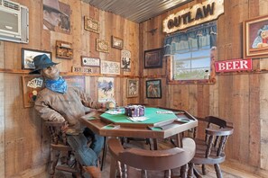 A wooden room with a poker table, chairs, and a sign that reads 'OUTLAW BEER.' - Wild West Town and Ranch Casita; 7 min. from Arizona Athletic Grounds AAG (Mesa)