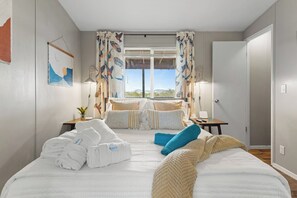 A hotel room with a bed, pillows, a bedside table, a lamp, and a view of the outdoors. - Wild West Town and Ranch Casita; 7 min. from Arizona Athletic Grounds AAG (Mesa)