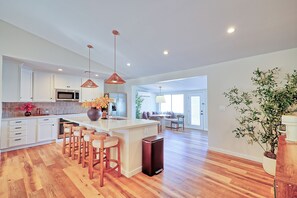 A modern kitchen with a central island, bar stools, and pendant lighting. - Scottsdale Retreat•Heated Pool•Sleeps 10 •Old Town (Scottsdale)