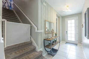 Un escalier menant à un palier où se trouvent une console et un miroir.