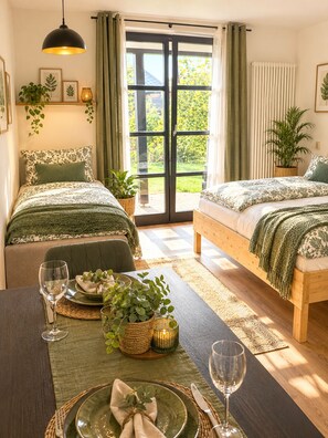 A cozy bedroom with two beds, a dining table set for two, and a large window with curtains. - New Listing (Welschneudorf)