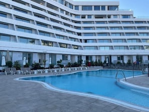 A modern hotel with a swimming pool, multiple balconies, and sun loungers. - סוויטה מרווחת  וממוזגת מיקום מנצח 5דקות הליכה מהים במתחם בריכת שחייה 
sea said92 (Eilat)
