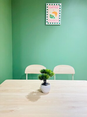 A small potted plant on a wooden table with two chairs. - Extra-Large Manchester City Centre Flat | 2 Bedrooms, 2 Bathrooms & TV Room (Manchester)
