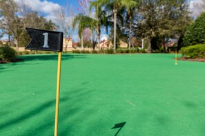 A golf course with a flag marking the first hole. - Family Fun, 5BR with Pool, Games & Themed Rooms (Kissimmee)