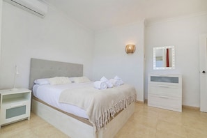 A bedroom with a bed, bedside tables, a mirror, and a wardrobe. - New Listing (Benalmádena)