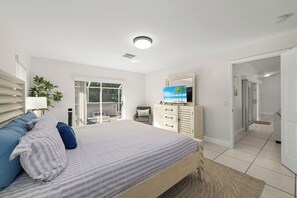 Une chambre à coucher avec un lit, une télévision, un bureau et une fenêtre.