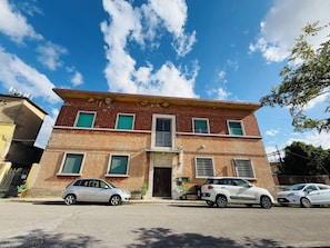 A two-story building with a flat roof, multiple windows, and a visible entrance. - Sabrina Guest House (Pisa)