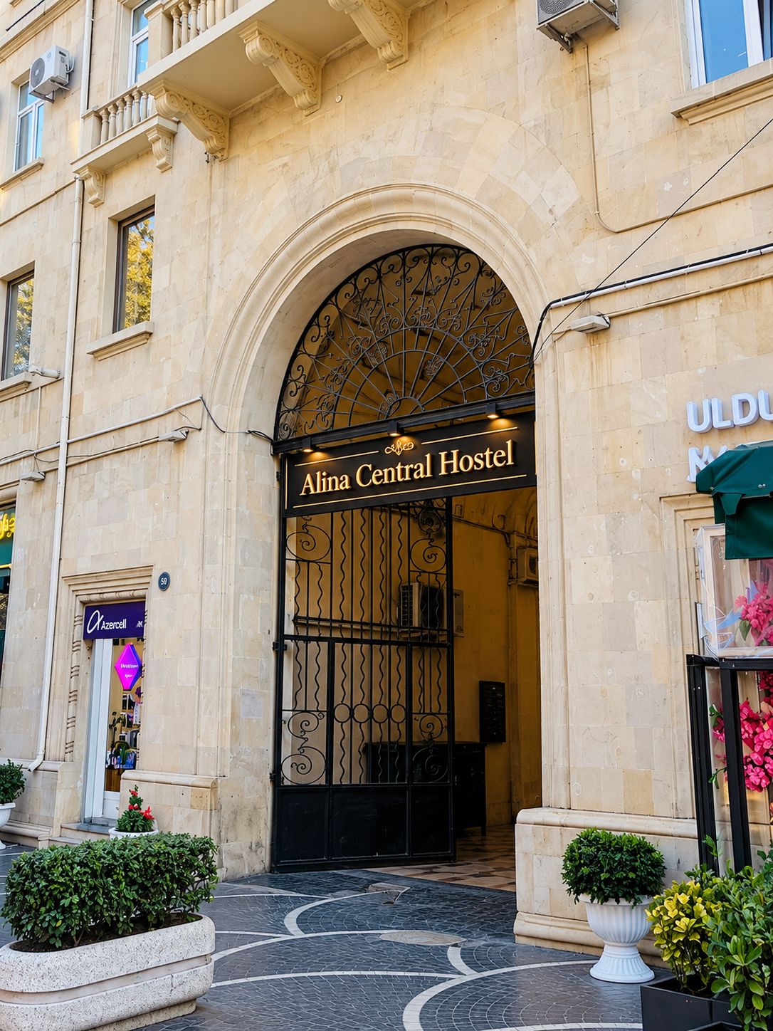 The entrance to Alina Central Hostel with an arched doorway and a sign above.
