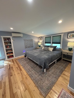 Une chambre à coucher avec un lit, une bibliothèque et une fenêtre.