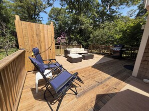 A wooden deck with outdoor furniture, including a sofa and chairs, and a grill. - Relaxing Vineyard Retreat, FREE CAR, Fenced yard, Pet Friendly, Sleeps 10! (West Tisbury)