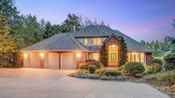 Une maison à deux étages avec un garage, un porche à l’avant et une allée.