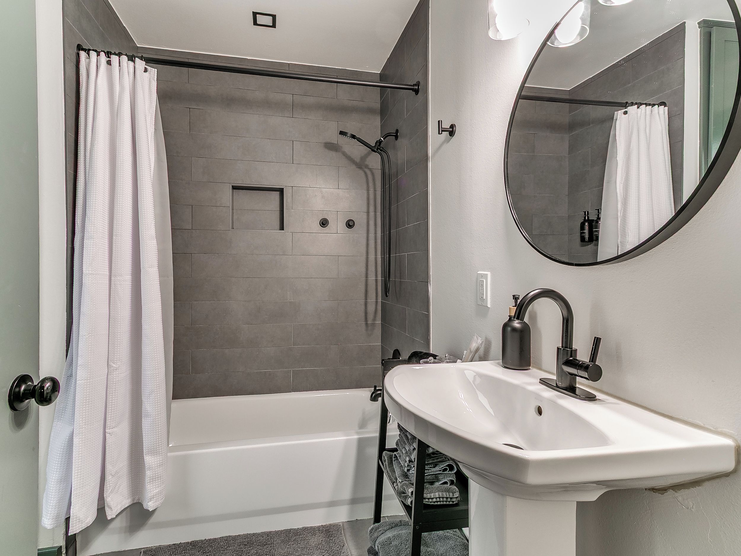A modern bathroom with a bathtub, a shower, and a sink.