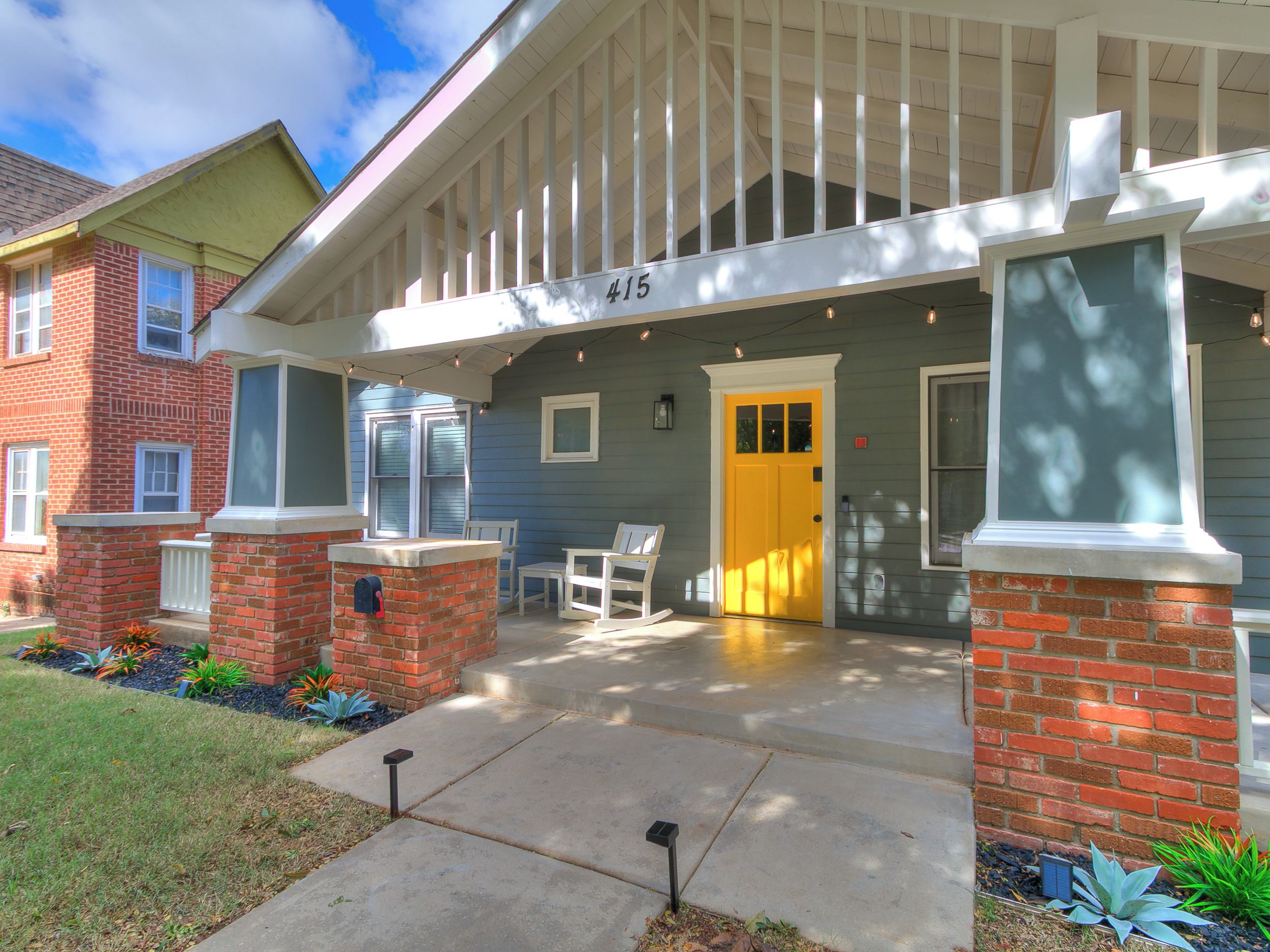 A residential building with a porch, a mailbox, and a door marked with the number 415.