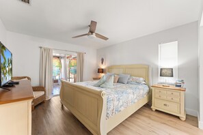 A bedroom with a bed, bedside tables, a desk, and a ceiling fan. - 2-bedroom townhome Island living Canal front Walk to the BEACH (Jensen Beach)