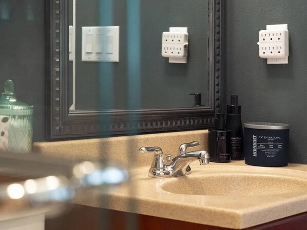 Un bagno con lavandino, specchio e articoli da toilette.