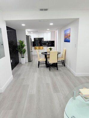 A modern kitchen with white cabinets, a black countertop, and a stainless steel refrigerator. - Spacious Black Luxe Retreat with 2 Kitchens, 2 Master Suites & Luxury Comfort (Tampa)