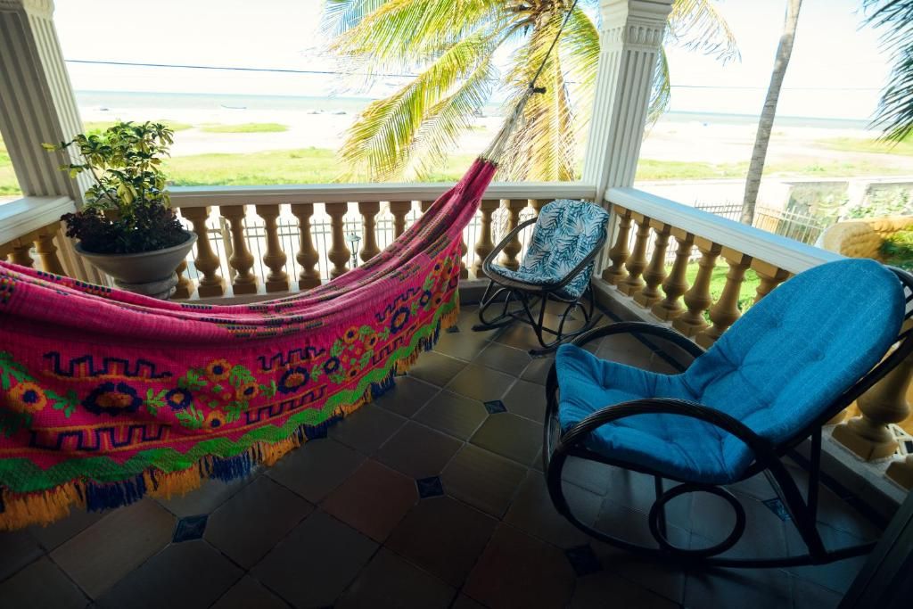 Ein Balkon mit einer Hängematte, einem Sessel und einem Topfpflanzen.