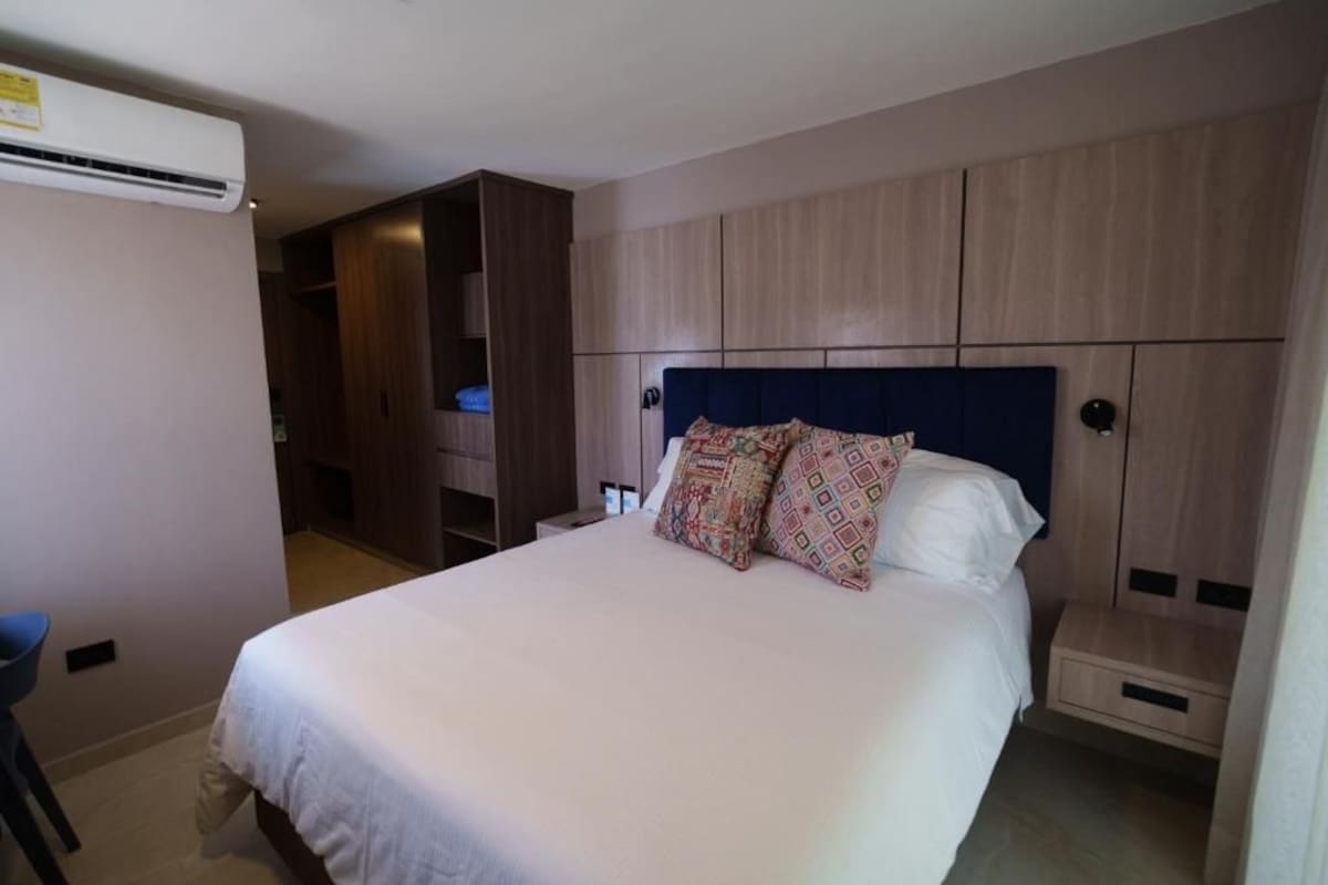 Une chambre d’hôtel avec un lit, une armoire et un bureau.