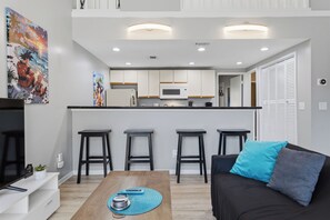 Un appartement moderne comprenant une cuisine, un coin repas et un salon.