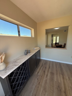 A kitchen with a marble countertop, a window, and a view of a dining area. - Come for the Views, Stay for the Escape (Green Valley)