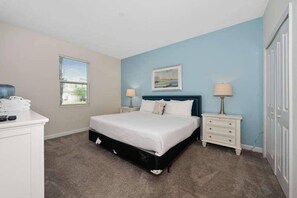 A bedroom with a bed, bedside tables, a dresser, and a window with blinds. - Family Paradise | 6BR | Near Disney (Davenport)