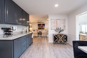 A modern kitchen with grey cabinets, a marble countertop, and a wine rack. - Charming 3-bedroom 2 bath house on Lake Hamilton in Hot Springs (Hot Springs)