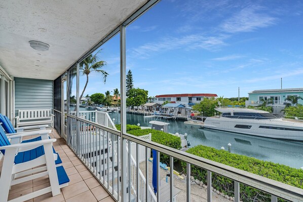 A balcony with a view of a marina, including boats and buildings. - Sombrero Beach Hideaway | Dockage, Close to Beach (Marathon)