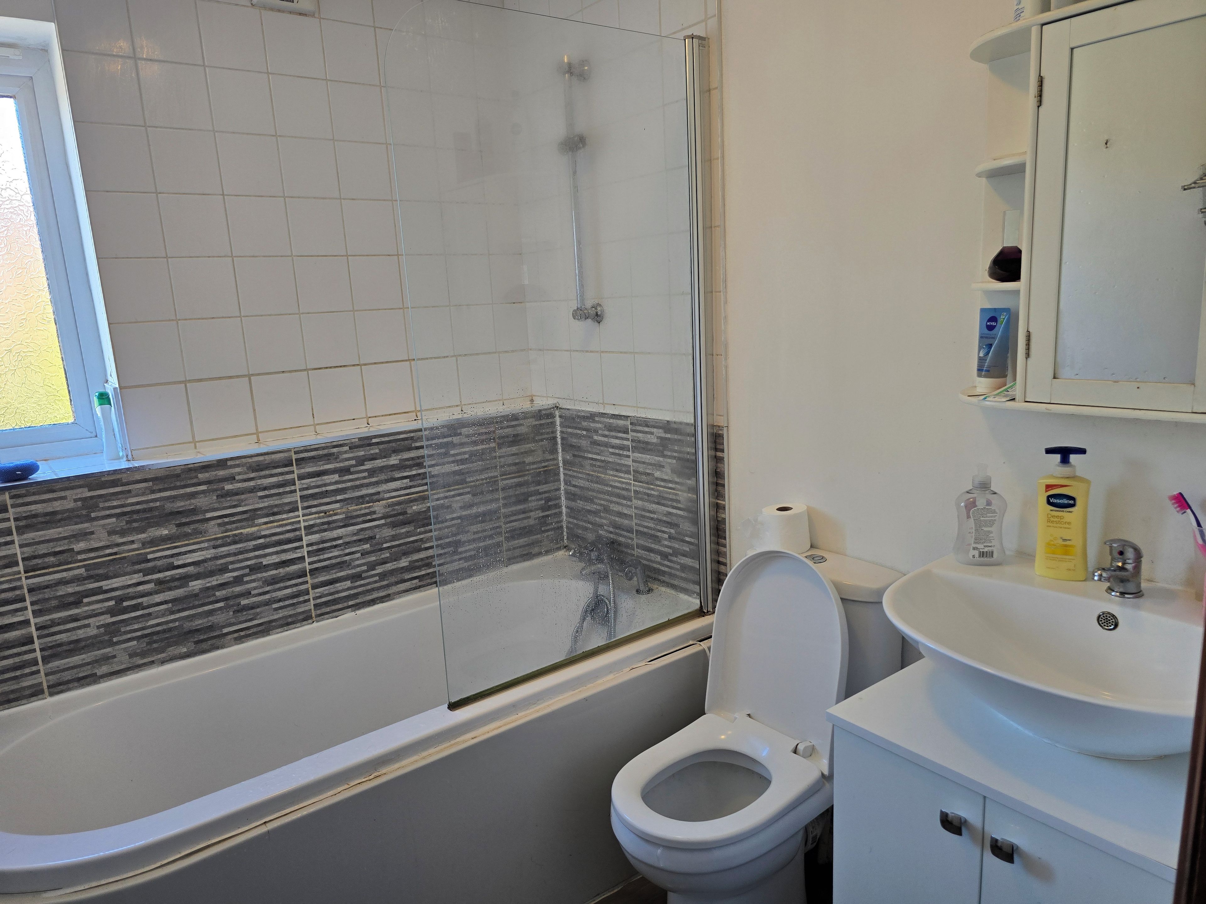 A bathroom with a bathtub, toilet, and sink.