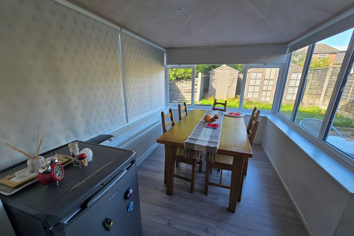 Spiseplads med et bord, stole, en radiator og udsigt ud