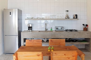 Una cocina moderna con refrigerador integrado, cafetera, tostadora y estufa a gas.