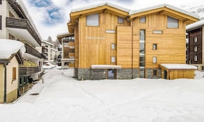 A wooden chalet with a sign reading 'Chalet Rutsch' in a snowy village setting. - SPACIOUS MOUNTAIN APARTMENT WITH LARGE SOUTH-FACING BALCONY (Zermatt)