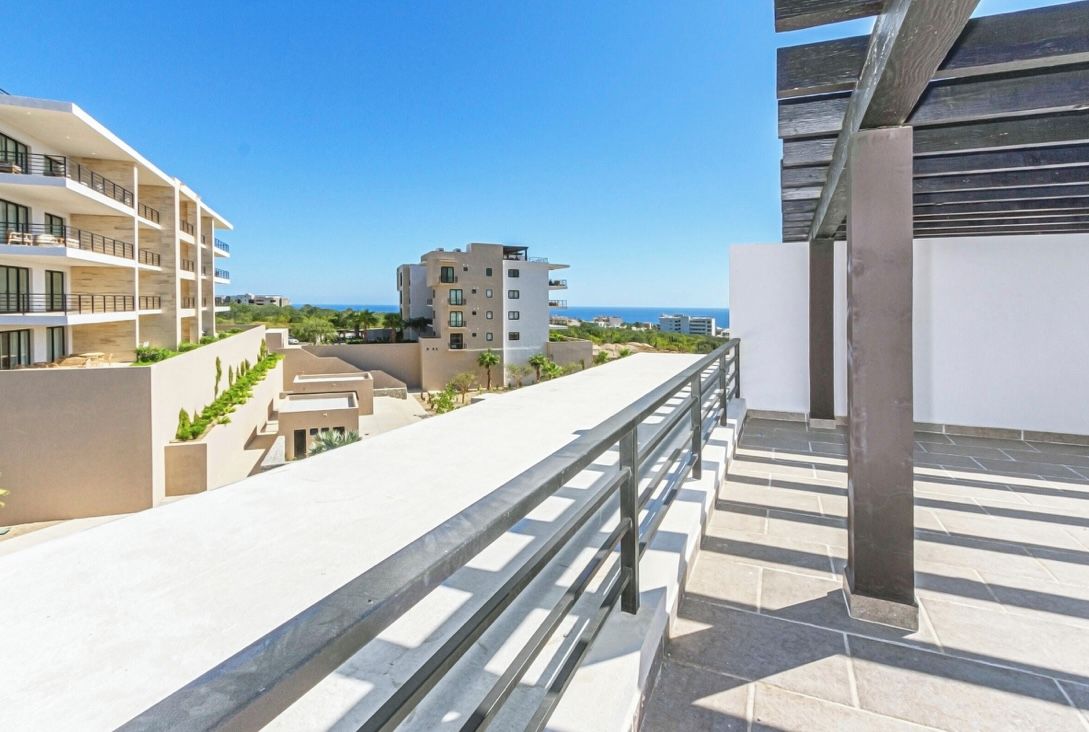A modern building with multiple balconies, a clear view of the sea, and a well-maintained outdoor area.