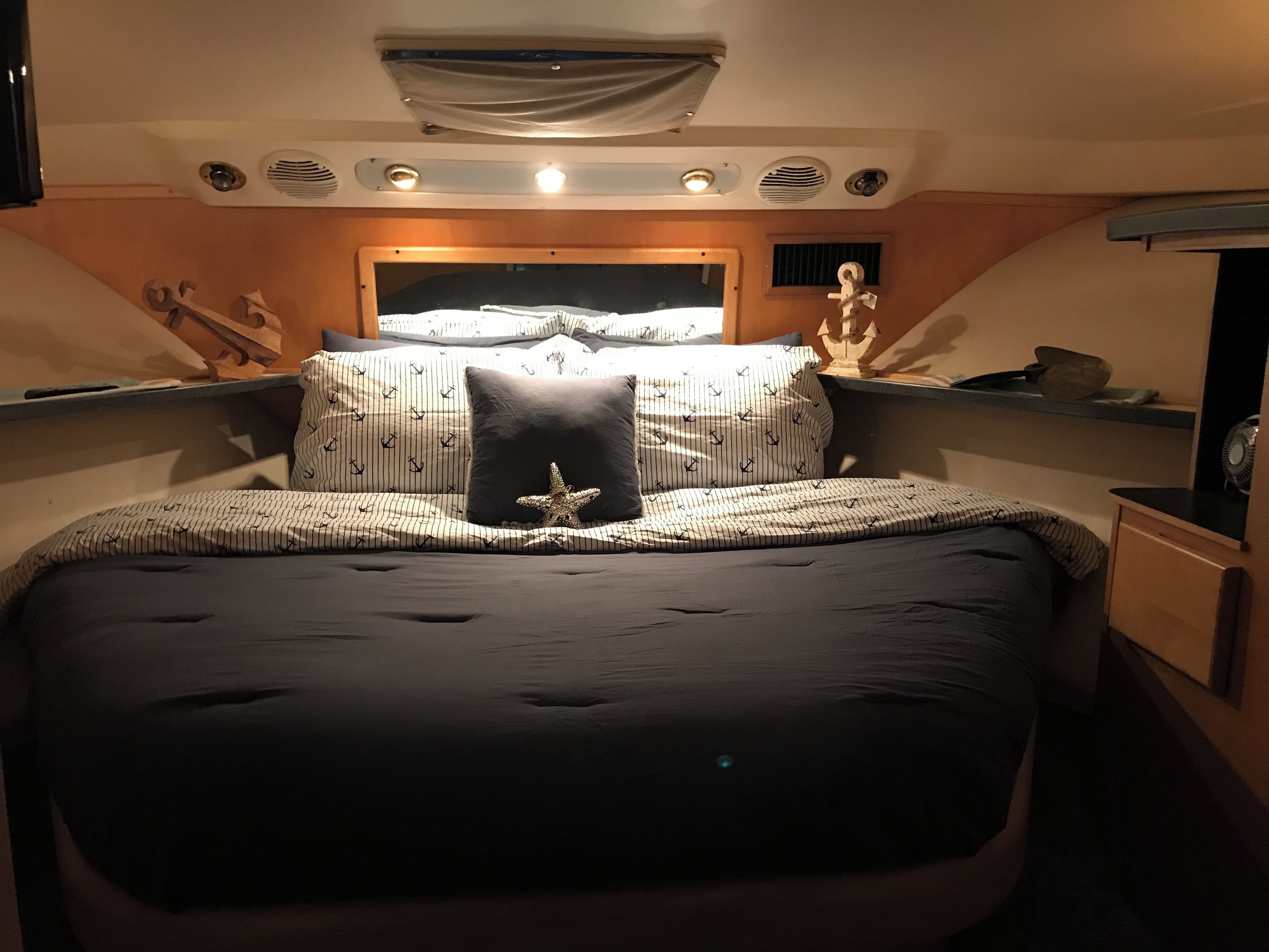 A bedroom with a large bed, a starfish decoration, and a window with curtains.