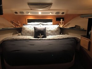 A bedroom with a large bed, a starfish decoration, and a window with curtains. - Marvelous 2-bedroom boat with AC in downtown Corpus Christi (Corpus Christi)