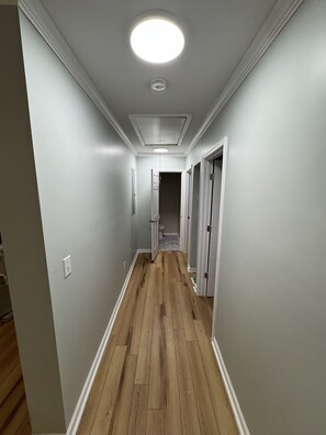 A hallway with a wooden floor, white walls, and a ceiling light. - Mizpah Manor House - Renovated, Walk to Waterfront (Washington)