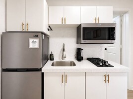 Una cocina moderna con electrodomésticos de acero inoxidable, un microondas integrado y una estufa a gas.