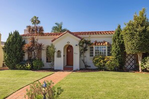 A single-story house with a red-tiled roof, a front entrance with a door, and a small porch. - San Diego Beaches, Surf Spots and Ocean Sunsets (San Diego)