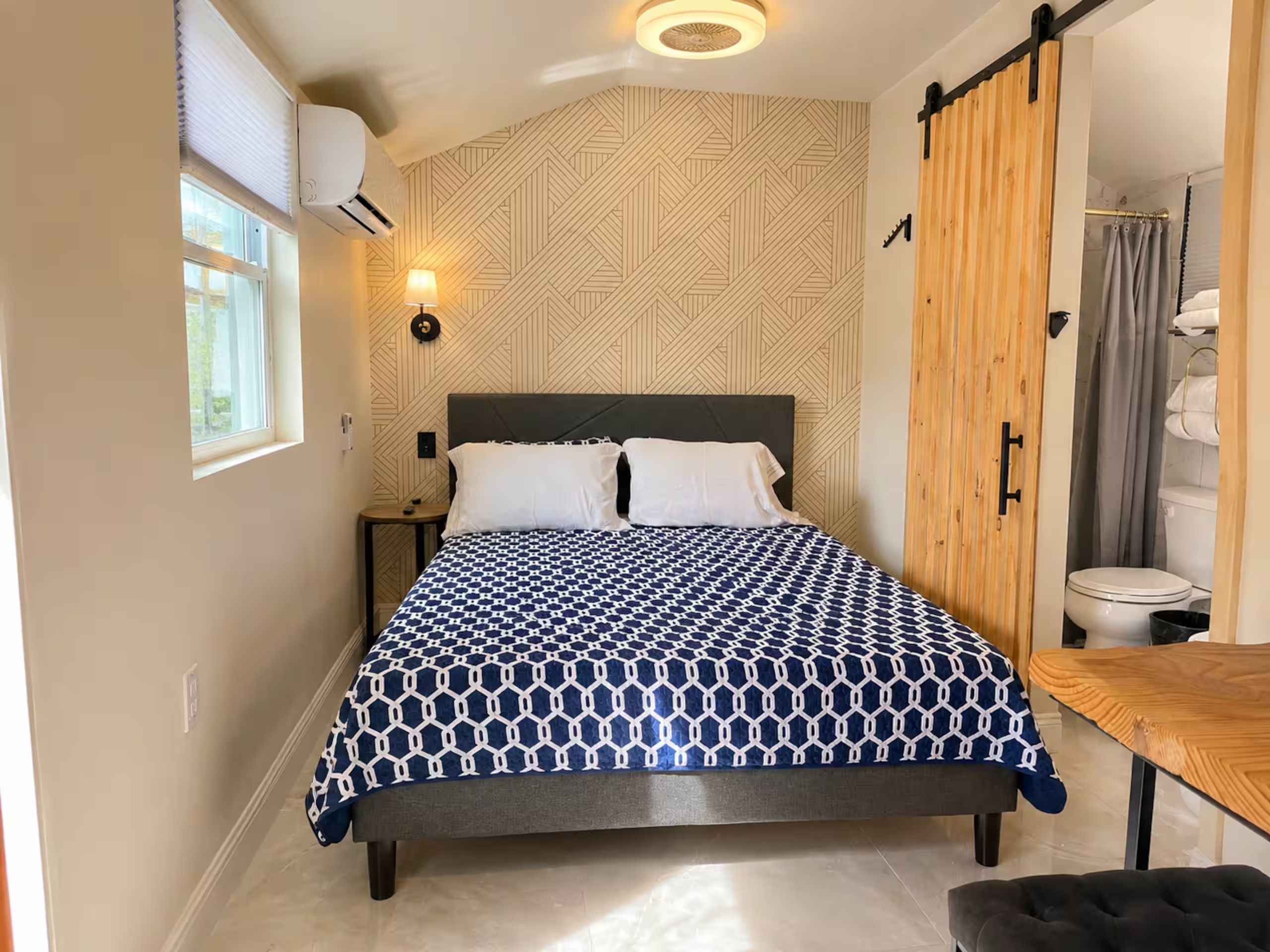 A bedroom with a bed, bedside table, and a wooden wardrobe.
