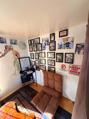 A room with a wall decorated with framed photos, a blackboard, and a sign prohibiting smoking. - Green Villa Private Resort Tropical Luxury, Private Pool & Nature Escape (Cavite)