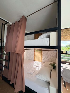 A bunk bed room with a curtain, a plant, and a view of greenery outside. - Green Villa Private Resort Tropical Luxury, Private Pool & Nature Escape (Cavite)