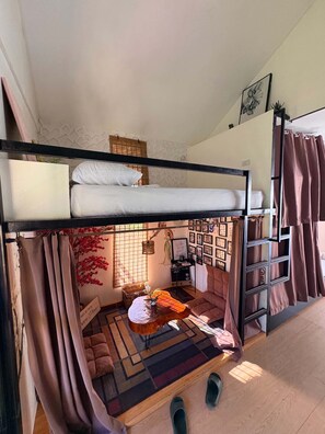 A bunk bed room with a ladder, a small table, and a wall of framed photos. - Green Villa Private Resort Tropical Luxury, Private Pool & Nature Escape (Cavite)